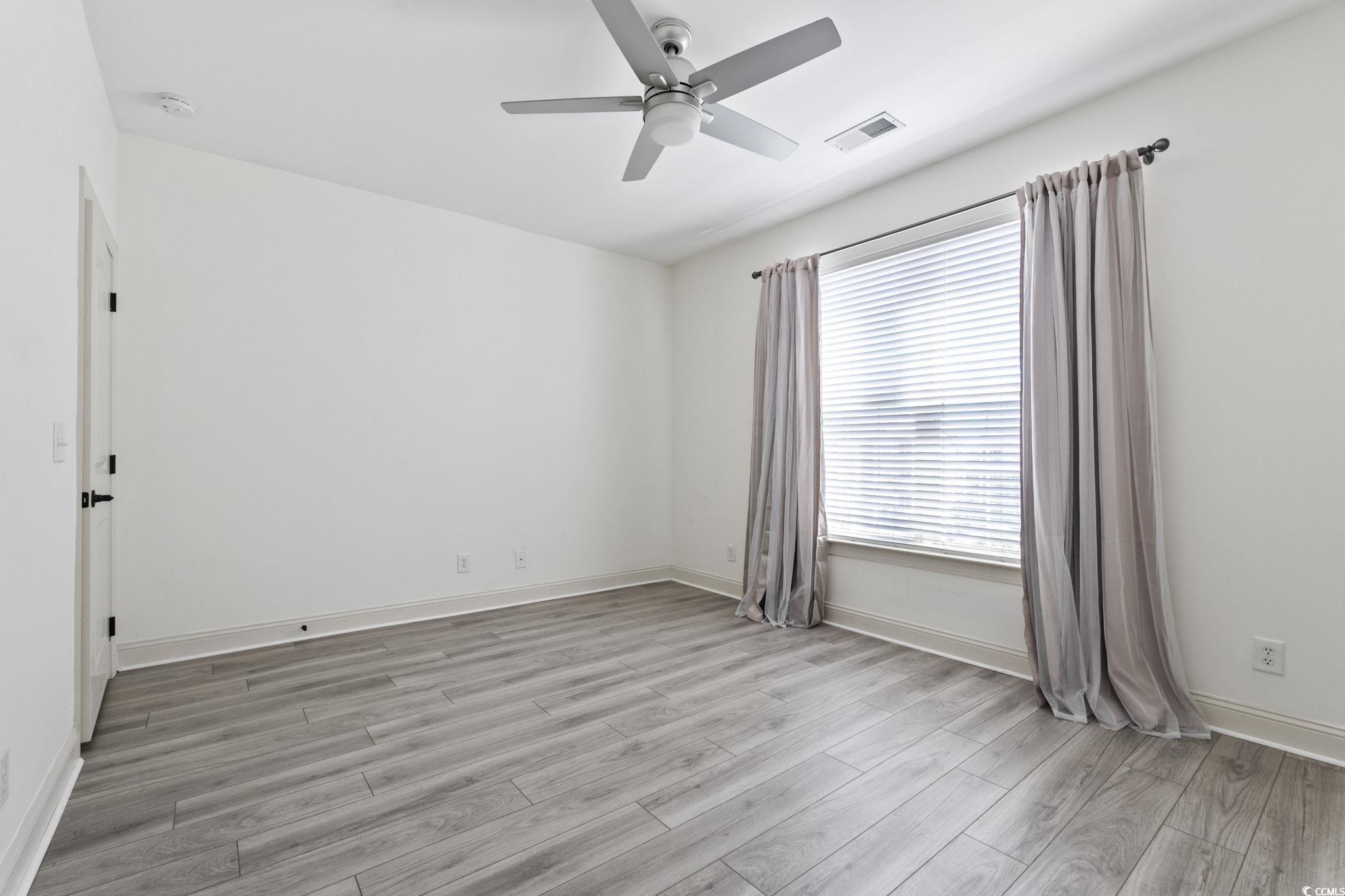 118 Ella Kinley Circle, Unit 404 Myrtle Beach, SC 29588 - Photo 19 of 22 Unfurnished room featuring light wood-style floors and a ceiling fan