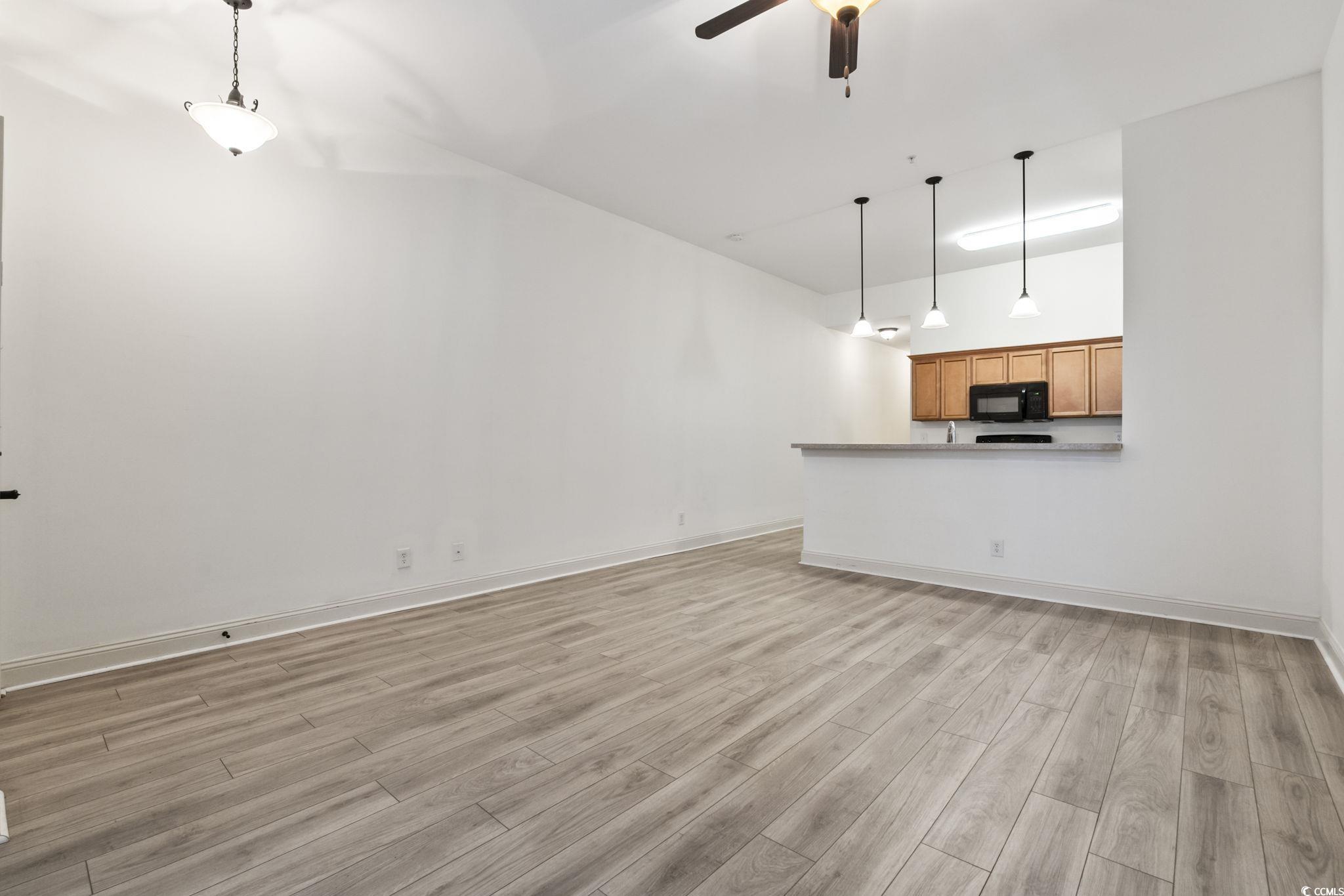 118 Ella Kinley Circle, Unit 404 Myrtle Beach, SC 29588 - Photo 7 of 22 Unfurnished living room featuring light wood-style flooring and ceiling fan