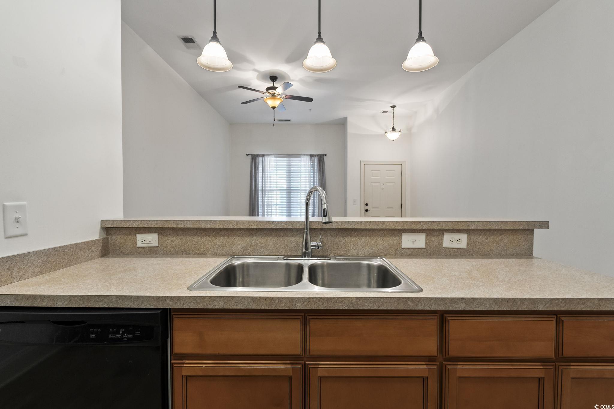 118 Ella Kinley Circle, Unit 404 Myrtle Beach, SC 29588 - Photo 10 of 22 Kitchen with black dishwasher, brown cabinets, hanging light fixtures, and light countertops