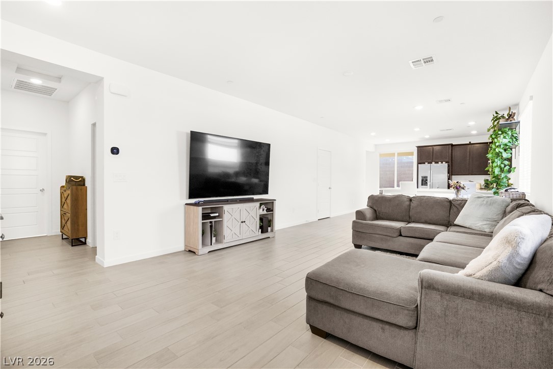 9398 Noble Fir Rdg Court Las Vegas, NV 89143 - Photo 6 of 36 An open-concept living space with sleek flooring seamlessly connects to the kitchen.