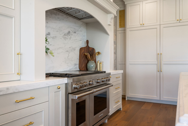 115 East Hidden Ridge Lane, Unit 42 Mapleton, UT 84664 - Photo 13 of 103 Gourmet kitchen featuring a professional-grade stainless steel range, custom range hood, slab stone backsplash, light-toned cabinetry, and brass hardware