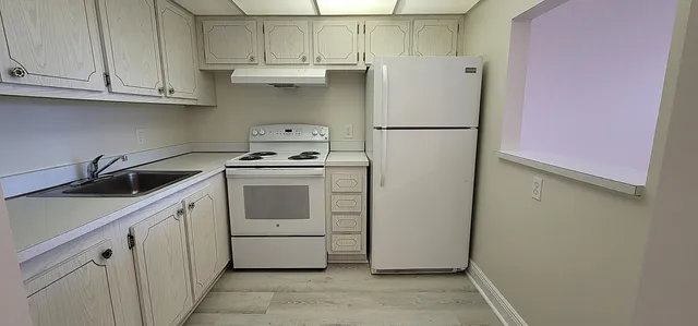 a kitchen with a white stove and white cabinets
