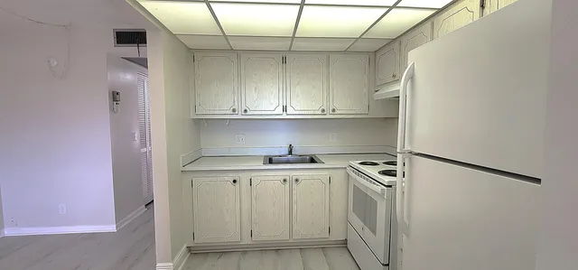a kitchen with a sink a stove and cabinets