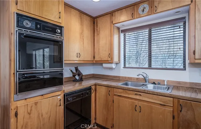 a kitchen with granite countertop a sink cabinets and stainless steel appliances