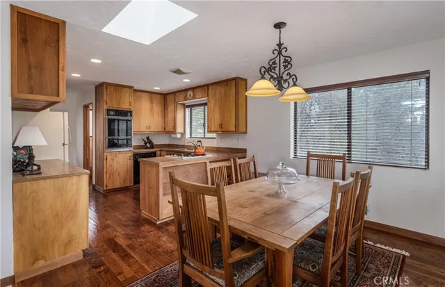 a kitchen with kitchen island a large counter top space appliances and a chandelier