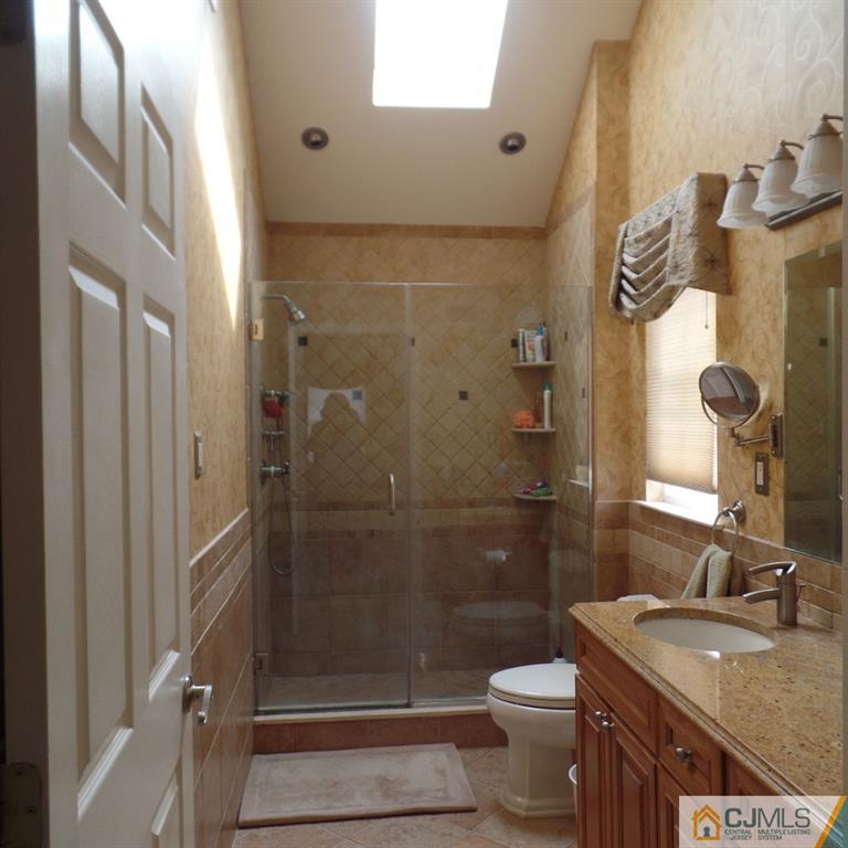 130 Dover Road Colonia, NJ 07067 - Photo 17 of 23 a bathroom with a granite countertop sink a toilet and shower