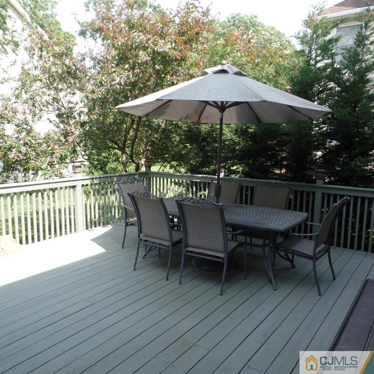 130 Dover Road Colonia, NJ 07067 - Photo 3 of 23 a view of a roof deck with table and chairs under an umbrella