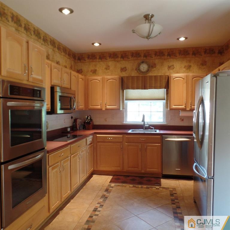 130 Dover Road Colonia, NJ 07067 - Photo 7 of 23 a kitchen with stainless steel appliances granite countertop a sink refrigerator and microwave