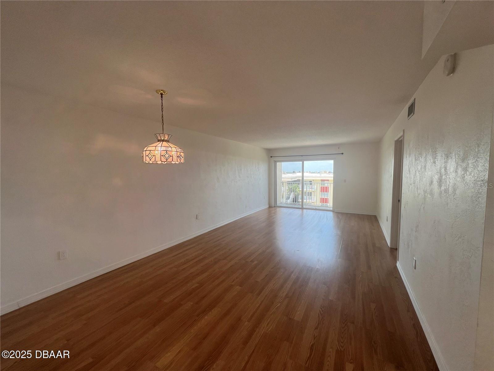 2711 North Halifax Avenue, Unit 593 Daytona Beach, FL 32118 - Photo 11 of 42 an empty room with wooden floor and window