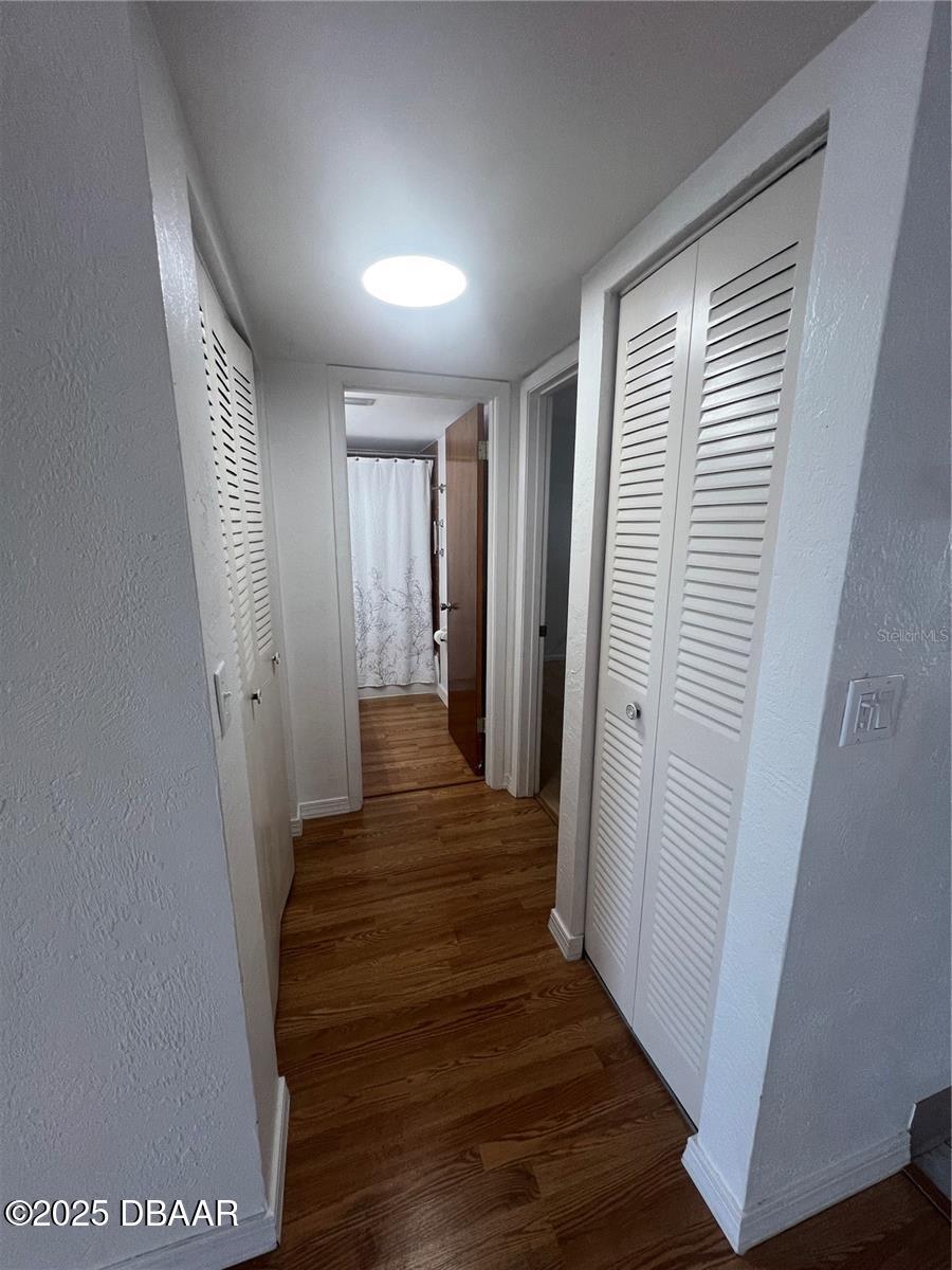 2711 North Halifax Avenue, Unit 593 Daytona Beach, FL 32118 - Photo 12 of 42 a view of a hallway with wooden floor and staircase
