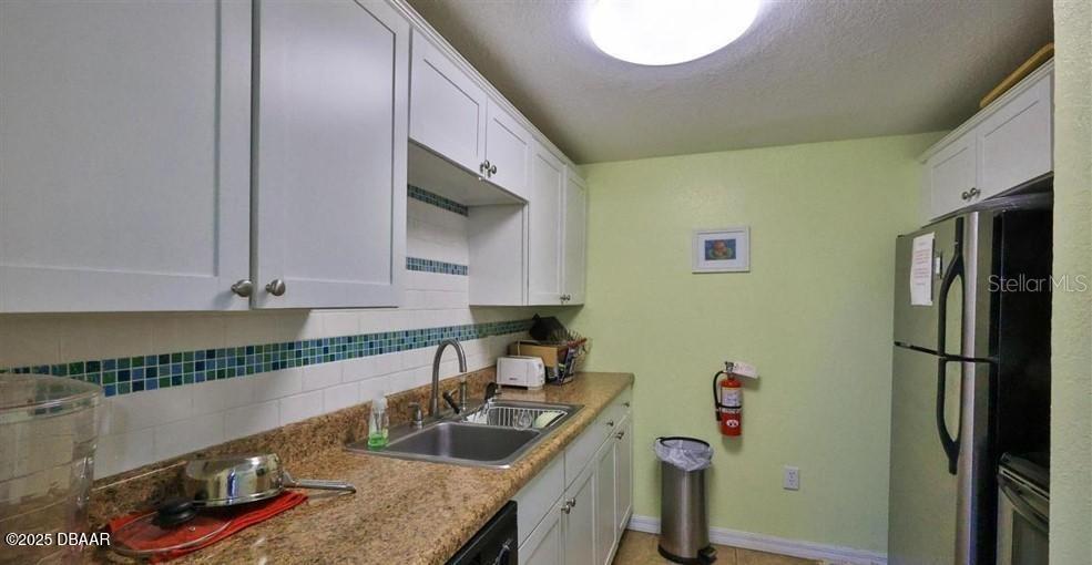 2711 North Halifax Avenue, Unit 593 Daytona Beach, FL 32118 - Photo 41 of 42 a kitchen with stainless steel appliances granite countertop a sink and a refrigerator