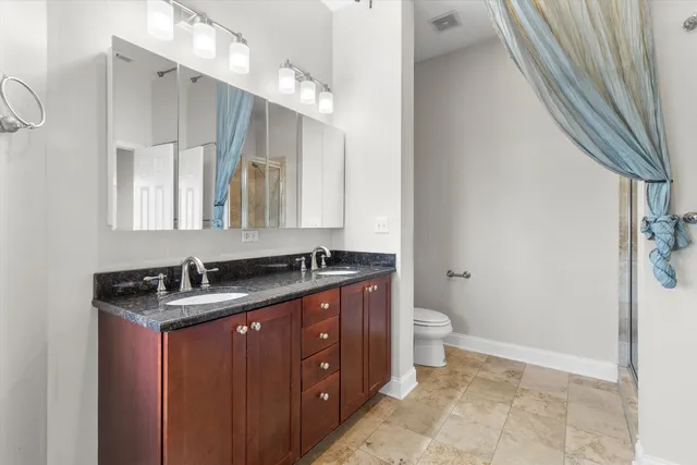 a white toilet sitting next to a bathroom sink