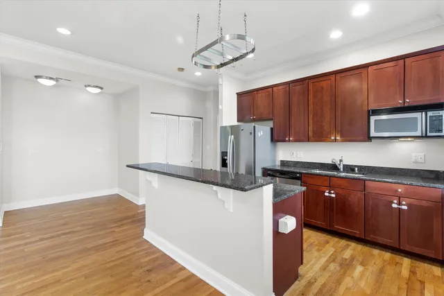 a kitchen with kitchen island a counter top space appliances and a ceiling fan