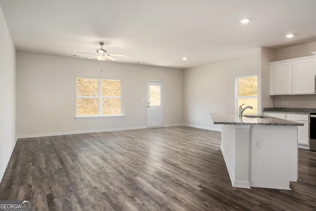 a view of an empty room with a window and wooden floor