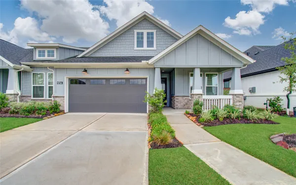 a front view of a house with a yard and potted plants