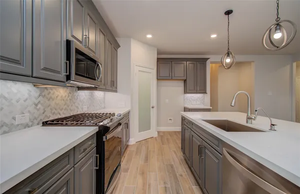 a large kitchen with stainless steel appliances granite countertop a large center island attached withe living room