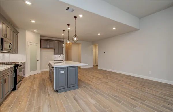 an empty room with wooden floor fireplace and windows