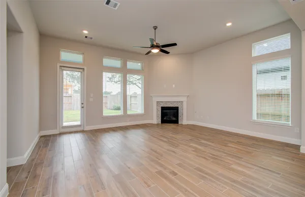 an empty room with a window and a ceiling fan