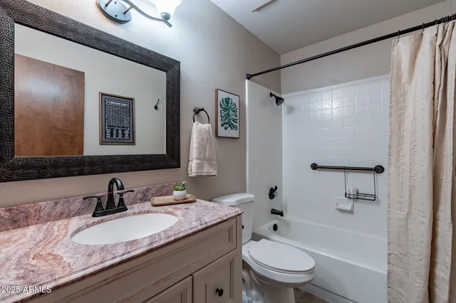 a bathroom with a granite countertop sink toilet and shower