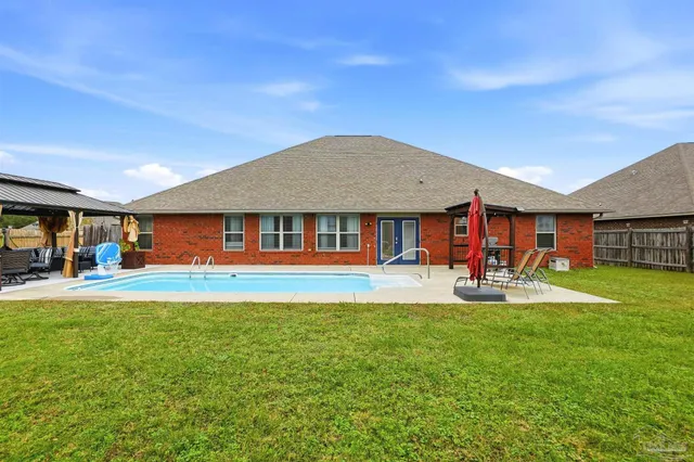 a view of a house with pool and sitting area