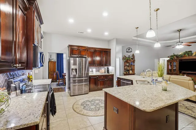 a kitchen with stainless steel appliances granite countertop a sink refrigerator and cabinets
