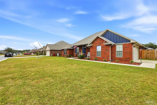 a view of a house with a big yard and large trees