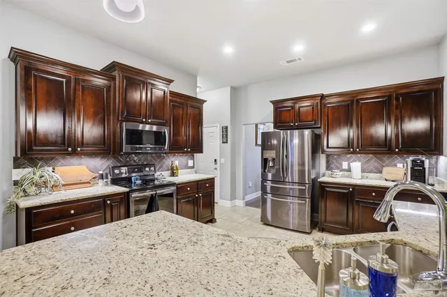 a kitchen with stainless steel appliances wooden cabinets and granite counter tops