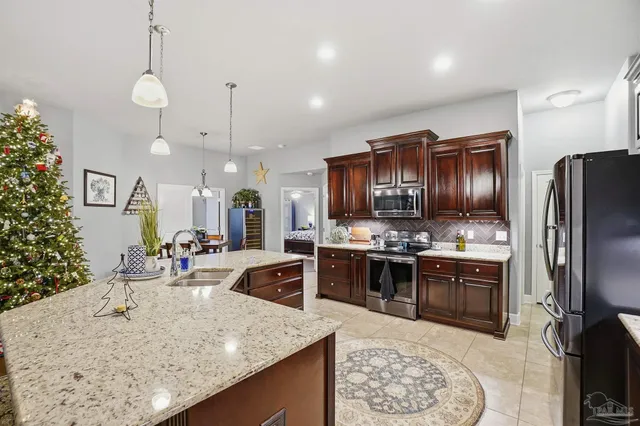 a kitchen with stainless steel appliances granite countertop a sink stove and refrigerator