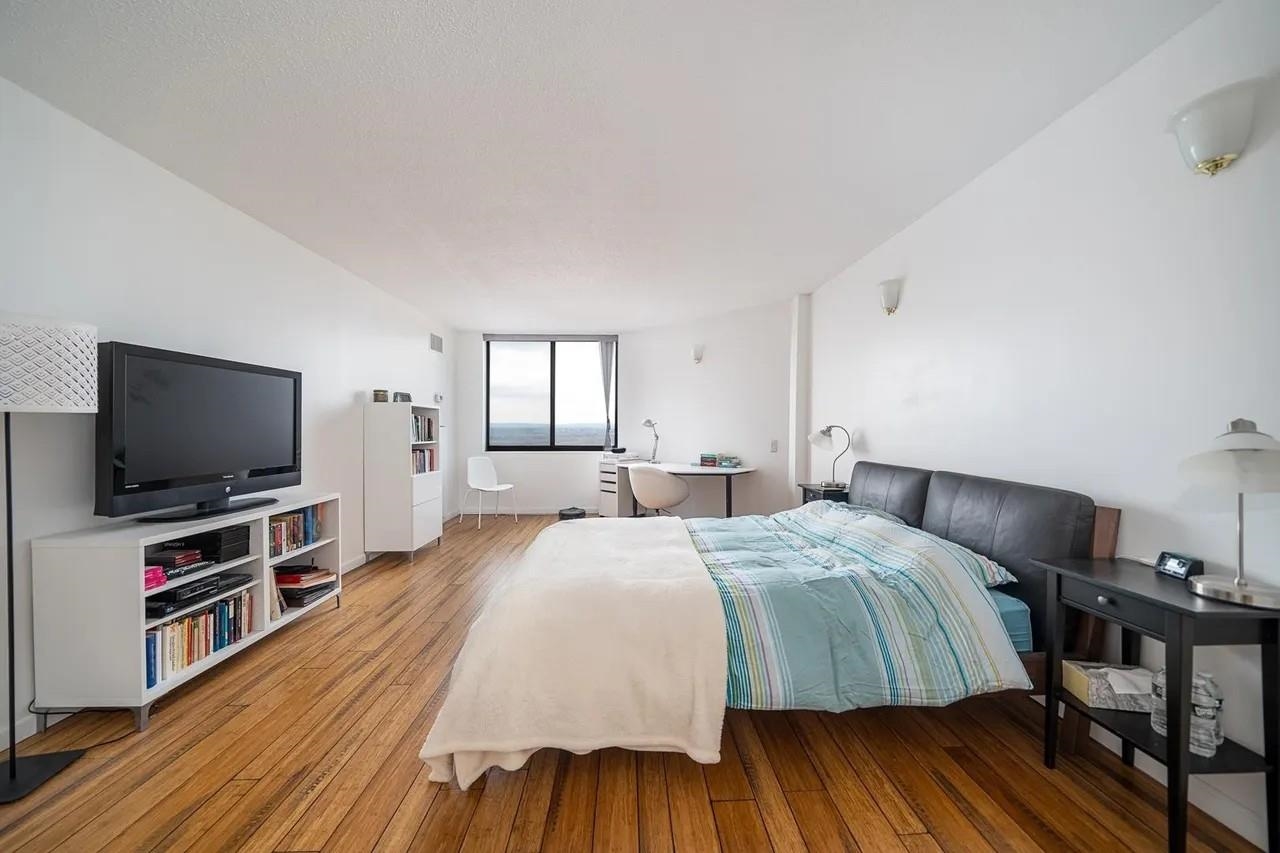 1908 Harmon Cove Tower, Unit 1908 Secaucus, NJ 07094 - Photo 15 of 49 a bedroom with a bed and a flat screen tv