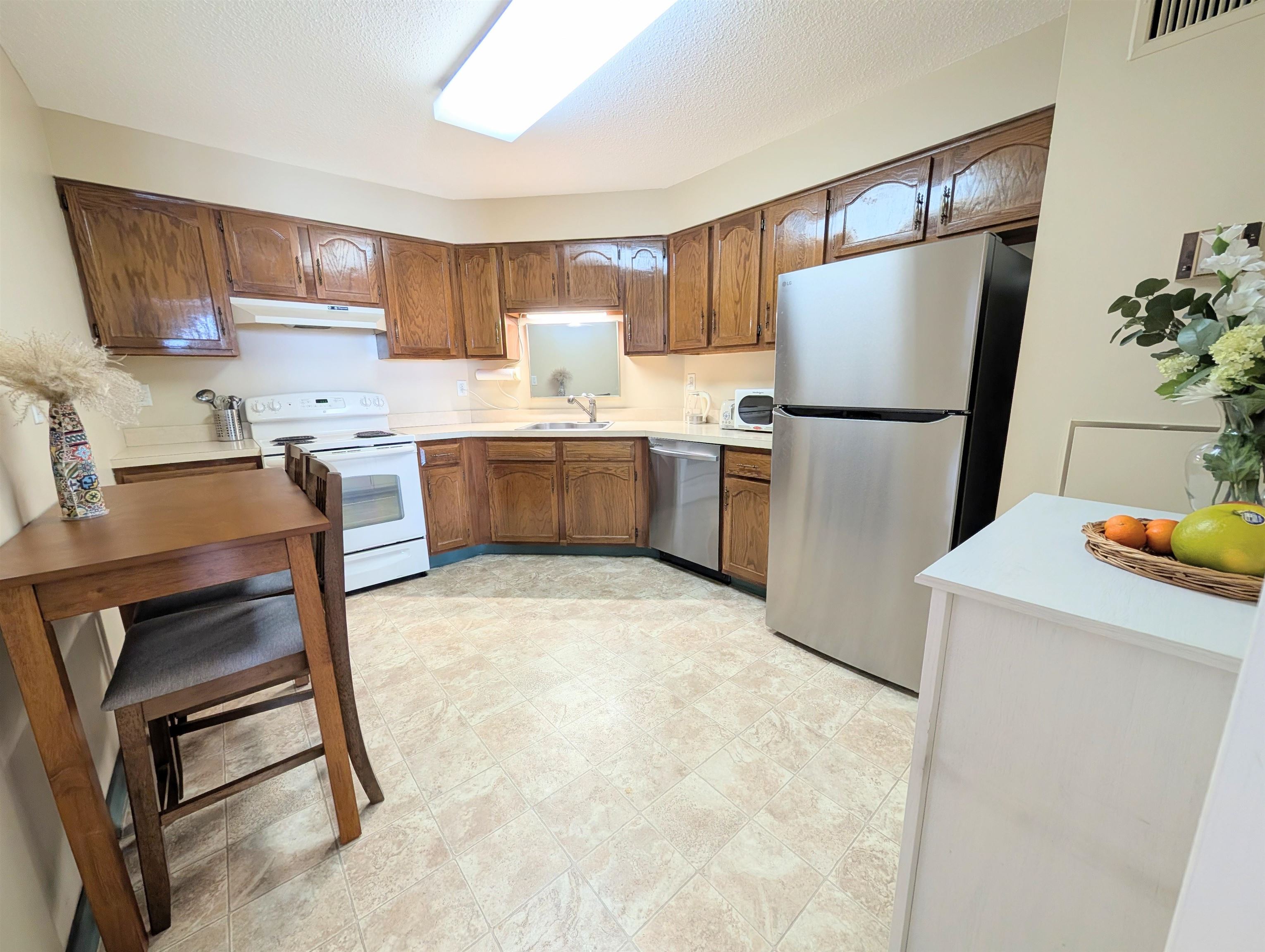 1908 Harmon Cove Tower, Unit 1908 Secaucus, NJ 07094 - Photo 6 of 49 a kitchen with a refrigerator a stove a sink a dining table and chairs