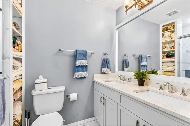 a bedroom with a bed and a lamp on dresser