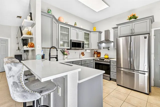 a kitchen with stainless steel appliances granite countertop a refrigerator a stove a microwave a sink and a refrigerator