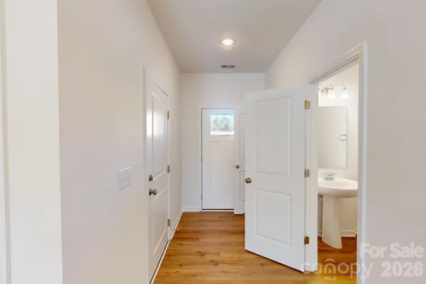 a view of a hallway with wooden floor and closet