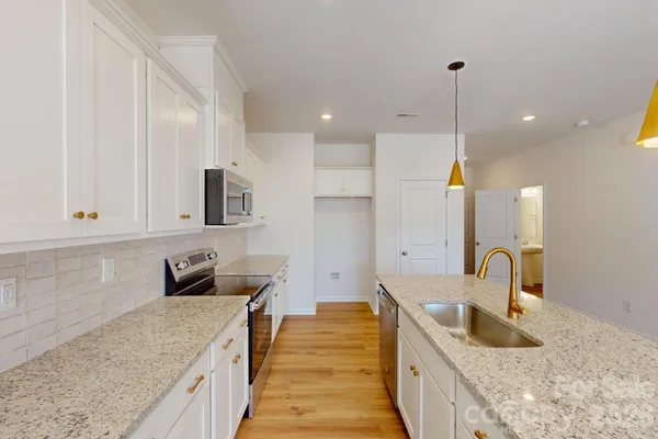 a kitchen with kitchen island granite countertop a sink and wooden cabinets