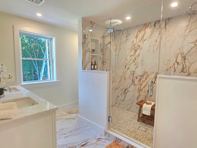a bathroom with a granite countertop sink a shower and a mirror