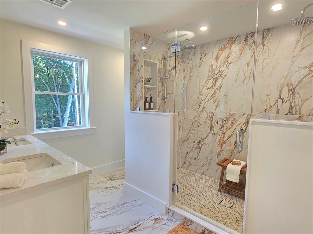 1 Danforth Drive Holliston, MA 01746 - Photo 25 of 42 a bathroom with a granite countertop sink a shower and a mirror