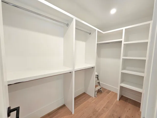 a room with walk in closet and wooden floor