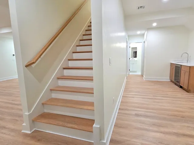 a view of a hallway with wooden floor and stairs