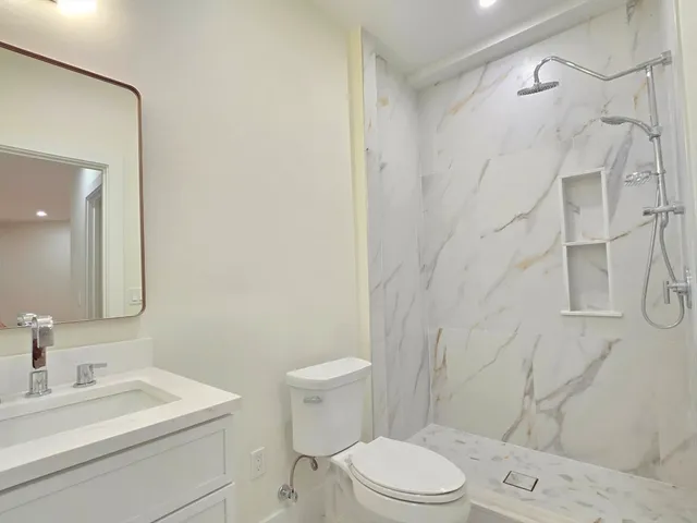 a bathroom with a sink a toilet and shower