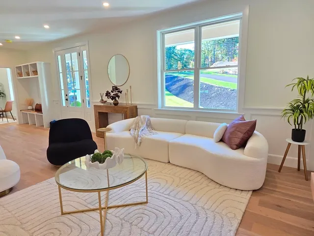 a living room with furniture potted plant and a large window