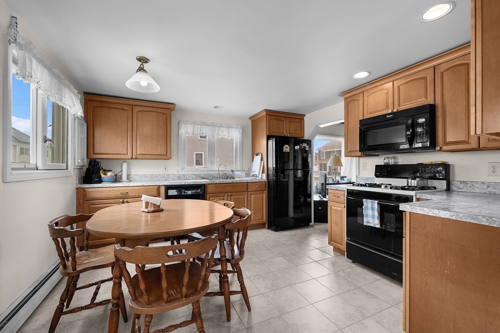 22 12th Road Marshfield, MA 02050 - Photo 8 of 42 a kitchen with stainless steel appliances granite countertop a stove a sink a microwave a refrigerator and chairs