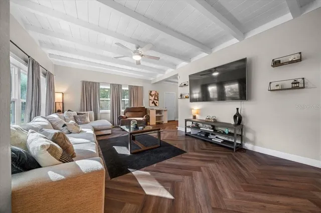 a living room with furniture wooden floor and a flat screen tv
