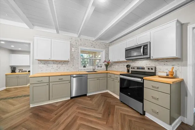 a kitchen with granite countertop a stove top oven sink and cabinets