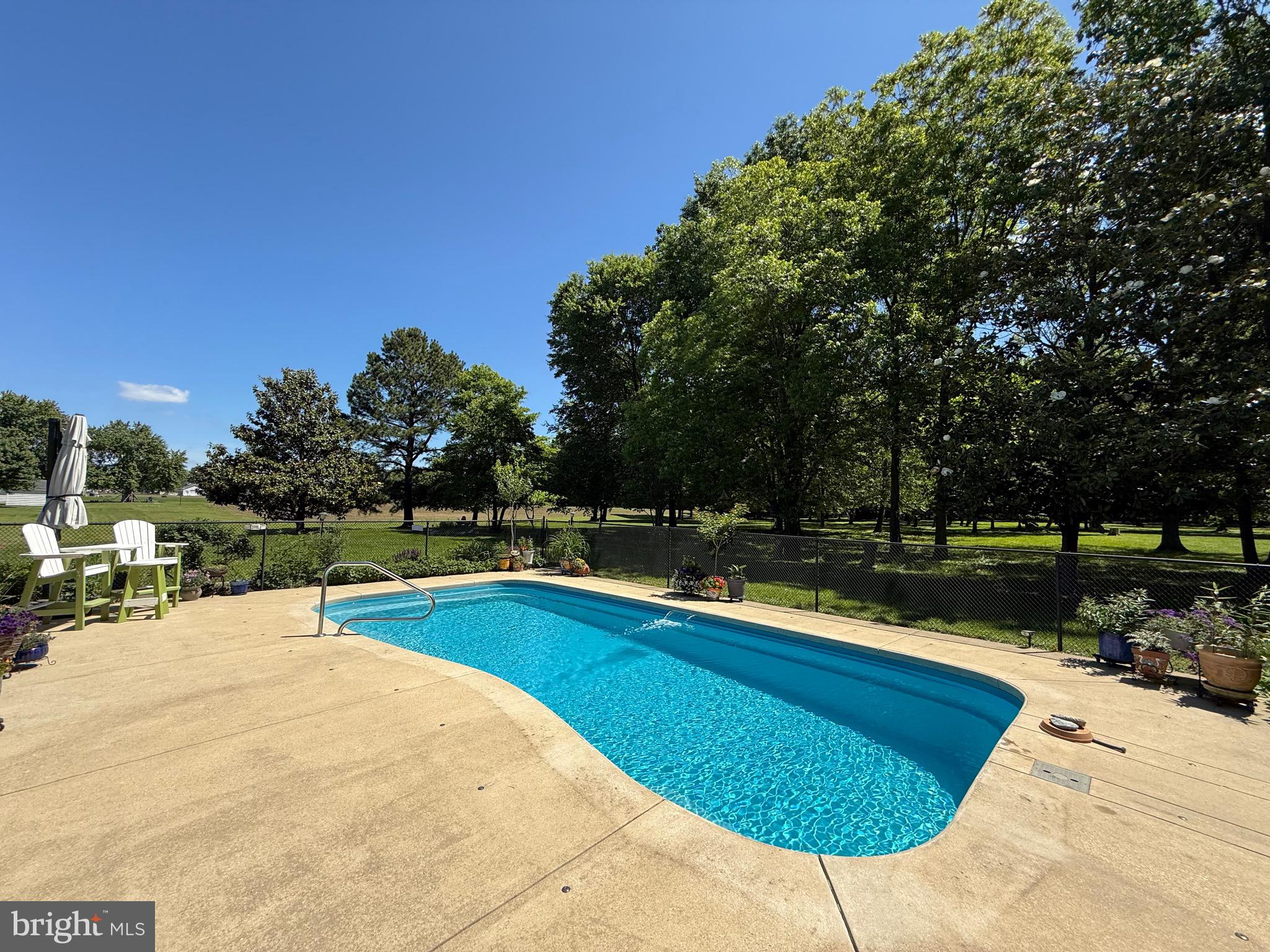 5737 Swamp Circle Road Deale, MD 20751 - Photo 54 of 58 a view of back yard with swimming pool outdoor seating and trees in the background