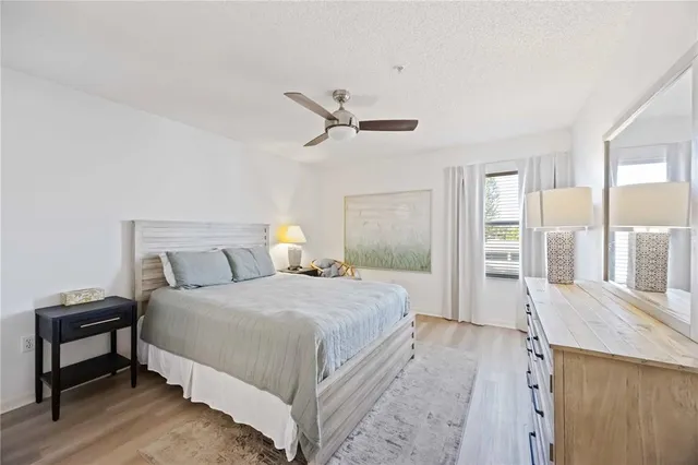 a bedroom with a bed a dresser and a chandelier