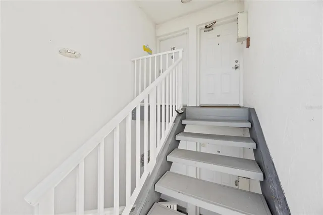a view of staircase with wooden floor and white walls