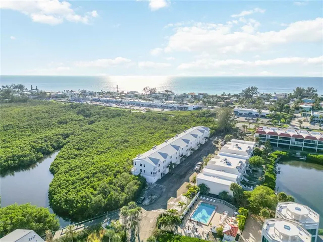 an aerial view of a house with a garden and lake view