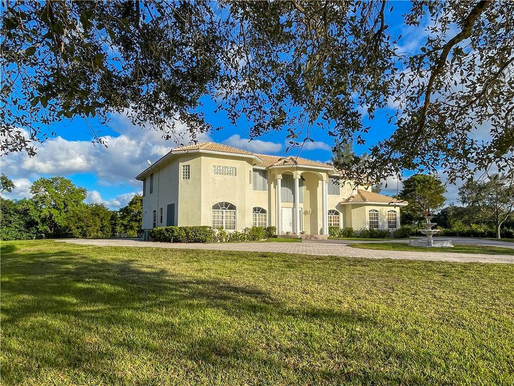 6150 Hancock Road Southwest Ranches, FL 33330 - Photo 2 of 41 a front view of a house with a garden