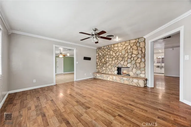 a view of an empty room with a window and a fireplace