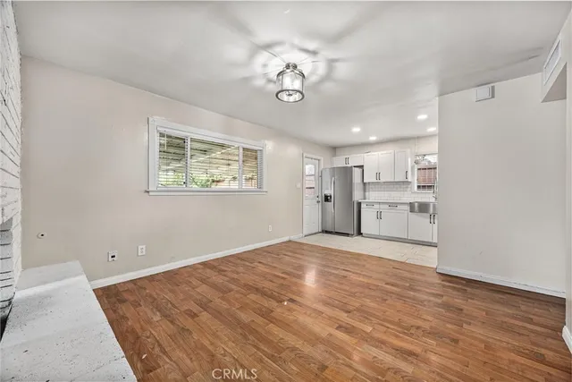 a view of empty room with wooden floor and window